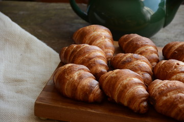 freshly baked croissants on wooden cutting board. Breakfast with croissants. 