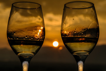 two glasses of wine in the background landscape with dramatic sky during sunset. The mountains in Myanmar, Inle lake