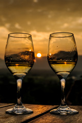 two glasses of wine in the background landscape with dramatic sky during sunset. The mountains in Myanmar, Inle lake