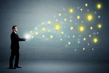 Fototapeta premium Businessman holding lightbulbs
