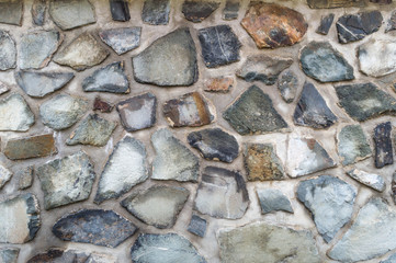 Old weathered stone wall texture. Part of a stone wall, for background or texture