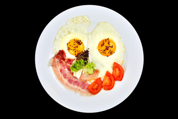 Isolated scrambled eggs with a bacon and tomatoes on a white plate.