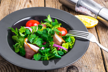 Salad with parma ham (jamon), tomatoes and fresh herbs