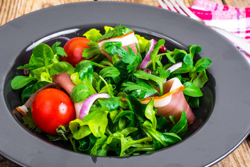 Salad with parma ham (jamon), tomatoes and fresh herbs