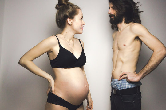 beautiful pregnant woman and her handsome boyfriend posing in lingerie