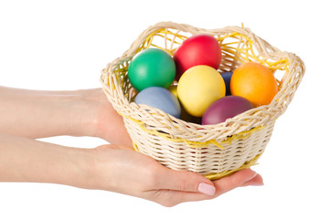 Easter color eggs in the basket in hand