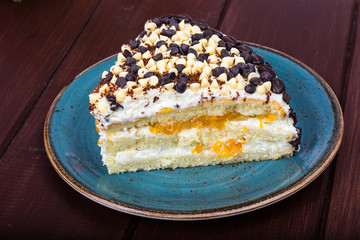 Delicious piece of cake with fruit, whipped cream and chocolate drops