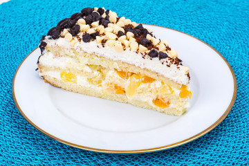 Delicious piece of cake with fruit, whipped cream and chocolate drops
