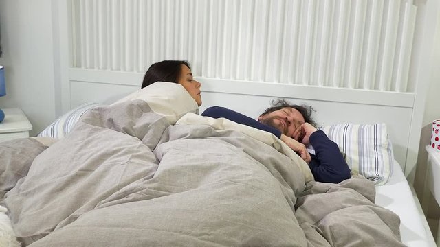 Woman trying to wake up husband in the morning