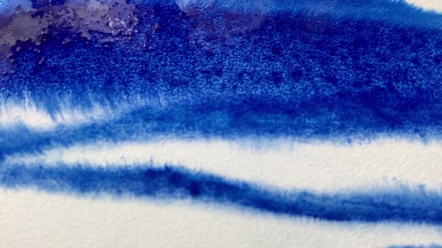 Dripping Ink on Paper. The paper absorbs Ink paint. Watercolor background.