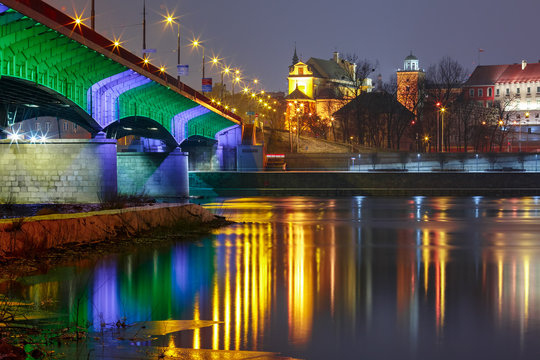 Slasko-Dabrowski Bridge in Old Town with reflection in the Vistula River during evening blue hour, Warsaw, Poland.