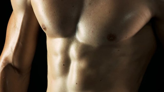 Muscular chest of young fitness man. Close up young athlete body with sexy abs. Concept of diet and training.