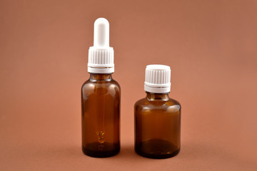 Two brown vials stock images. Empty cosmetic bottle. Vials on a brown background. Brown glass containers. Brown chemical glass
