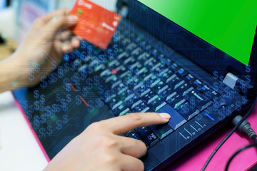 Woman hand on computer keyboard with credit card and eletronic circuit graphic.Symbolic of  online shopping,e-commerce,cyber crime and technology.