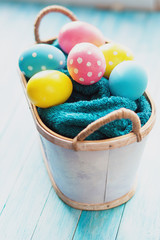 Easter eggs in the basket on rustic background