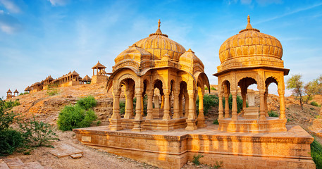 The royal cenotaphs of historic rulers, also known as Jaisalmer Chhatris, at Bada Bagh in Jaisalmer, Rajasthan, India. Cenotaphs made of yellow sandstone at sunset