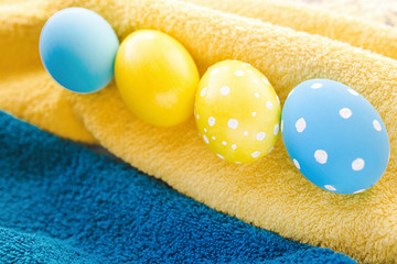 Blue and yellow Easter eggs on rustic background