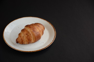 Fresh croissant on a black background.  