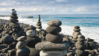 Stack of zen stones over water and blue sky. Shallow depth of field. Canary Islands