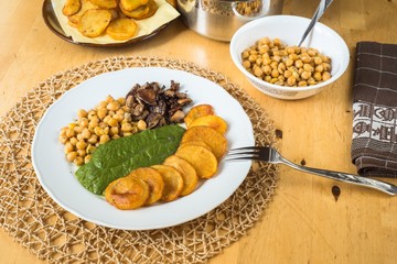 Potato,spinach, mushroom and chickpeas on table.