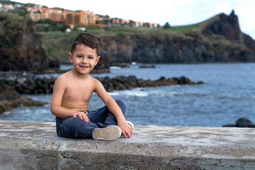 little boy sitting on the beach