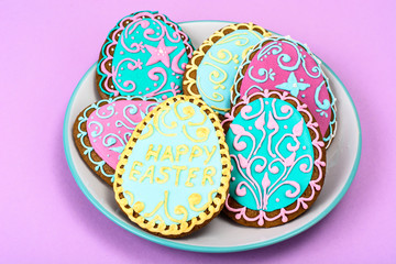 Fototapeta na wymiar Easter homemade baked gingerbread cookies in the form of eggs with different pattern of icing on plate
