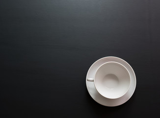 empty white cup for drinks with space for text on a black matte surface