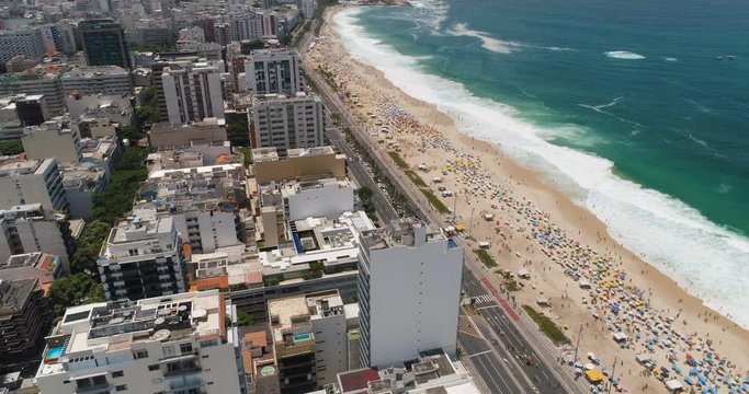Flying above city buildings and Ipanema Beach at sunny summer day in Rio de Janeiro, Brazil