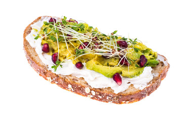 Whole grain bread with avocado, green sprouts and pomegranate seeds