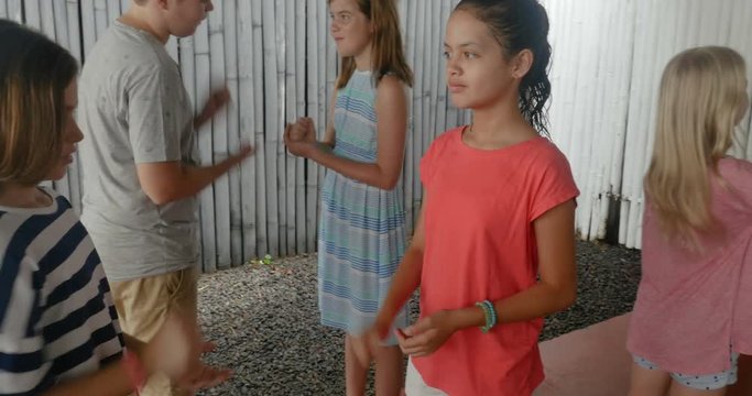 Diverse group of young boys and girls playing rock paper scissors