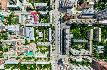 Aerial city view with crossroads and roads, houses, buildings, parks and parking lots, bridges. Helicopter drone shot. Wide Panoramic image.