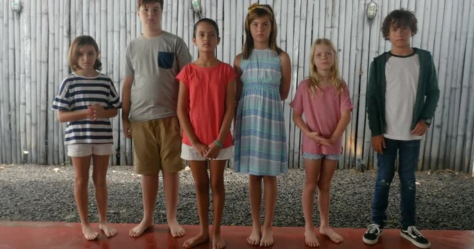 Group of nervous, anxious, unhappy boys and girls standing in a line together