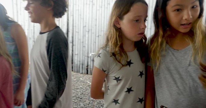 Mixed racial group of young boys and girls talking and sharing technology