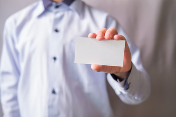 white business card with place for text in the hands of a man in a light shirt