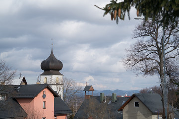Fototapeta na wymiar Church tower and homes rooftops in Karpacz