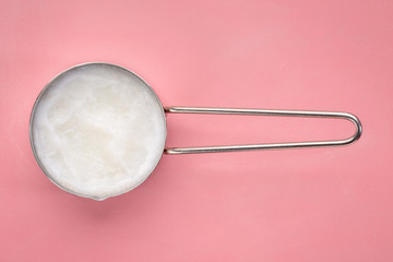 coconut cooking oil  in a measuring scoop