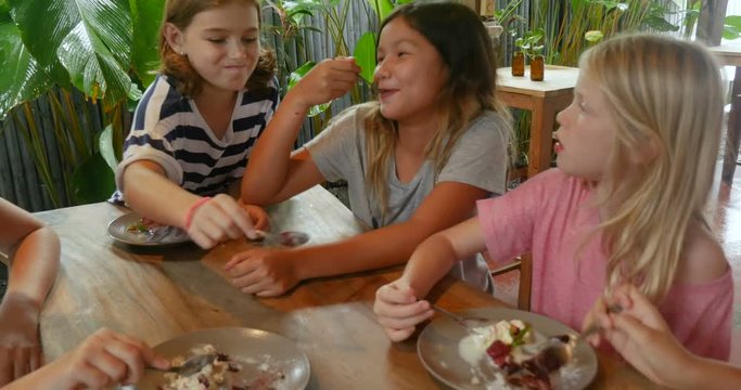 Happy young pre teenage girls sharing delicious desserts together