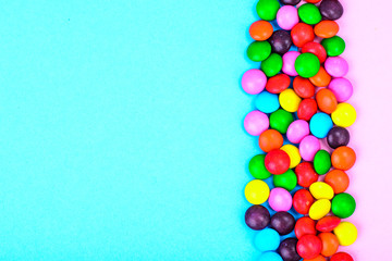 Small colored candy on bright background