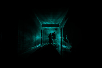Creepy silhouette in the dark abandoned building. Dark corridor with cabinet doors and lights with...