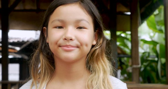 Portrait of young 11 - 12 year old cute happy Asian girl smiling