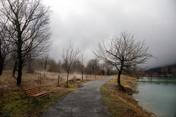Empty bench at park near pond by foggy day, minimalistic cold season scene. bench at the lake in the fog in the forest. Bench near lake with fog. Azerbaijan Nature.