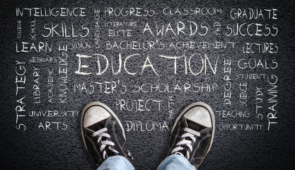 Teen Wearing Canvas Shoes on Asphalt With Education Word Cloud