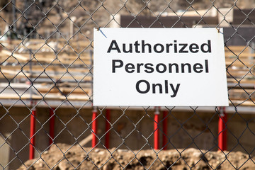 Authorized Personnel Only sign on a construction site fence