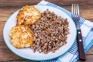 Buckwheat porridge with cutlets on white plate