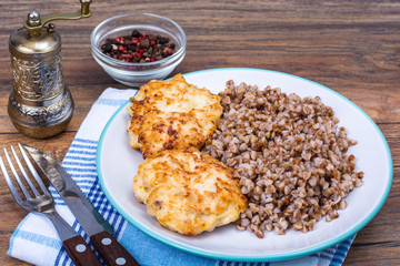 Buckwheat porridge with cutlets on white plate