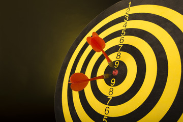 Dart board targeting the center on a  yellow background. abstract of success - close-up.