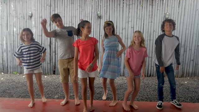 Diverse group of young pre teenage children jumping up in a line