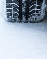 Closeup of car winter tires on the road covered with snow