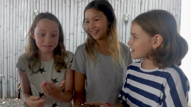 Group of three multi ethnic young girls age 11 - 12 sharing technology