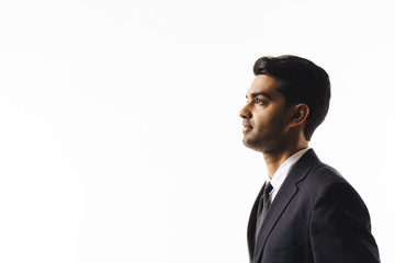 A profile portrait of a handsome man in suit and tie looking to side  isolated on white studio background